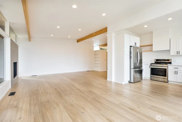 a kitchen with cabinets stainless steel appliances and wooden floor