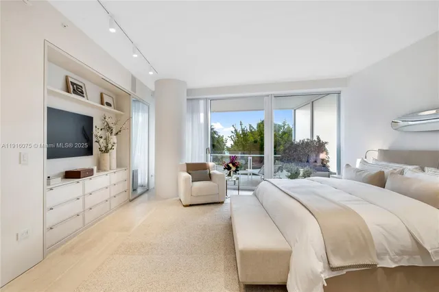 a spacious bedroom with a large bed and a flat screen tv