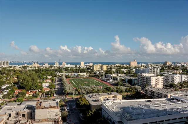 a living room with furniture a flat screen tv and floor to ceiling window
