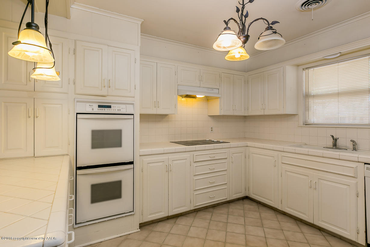 6107 Elmhurst Road Amarillo, TX 79106 - Photo 11 of 32 a kitchen with a stove cabinets and window