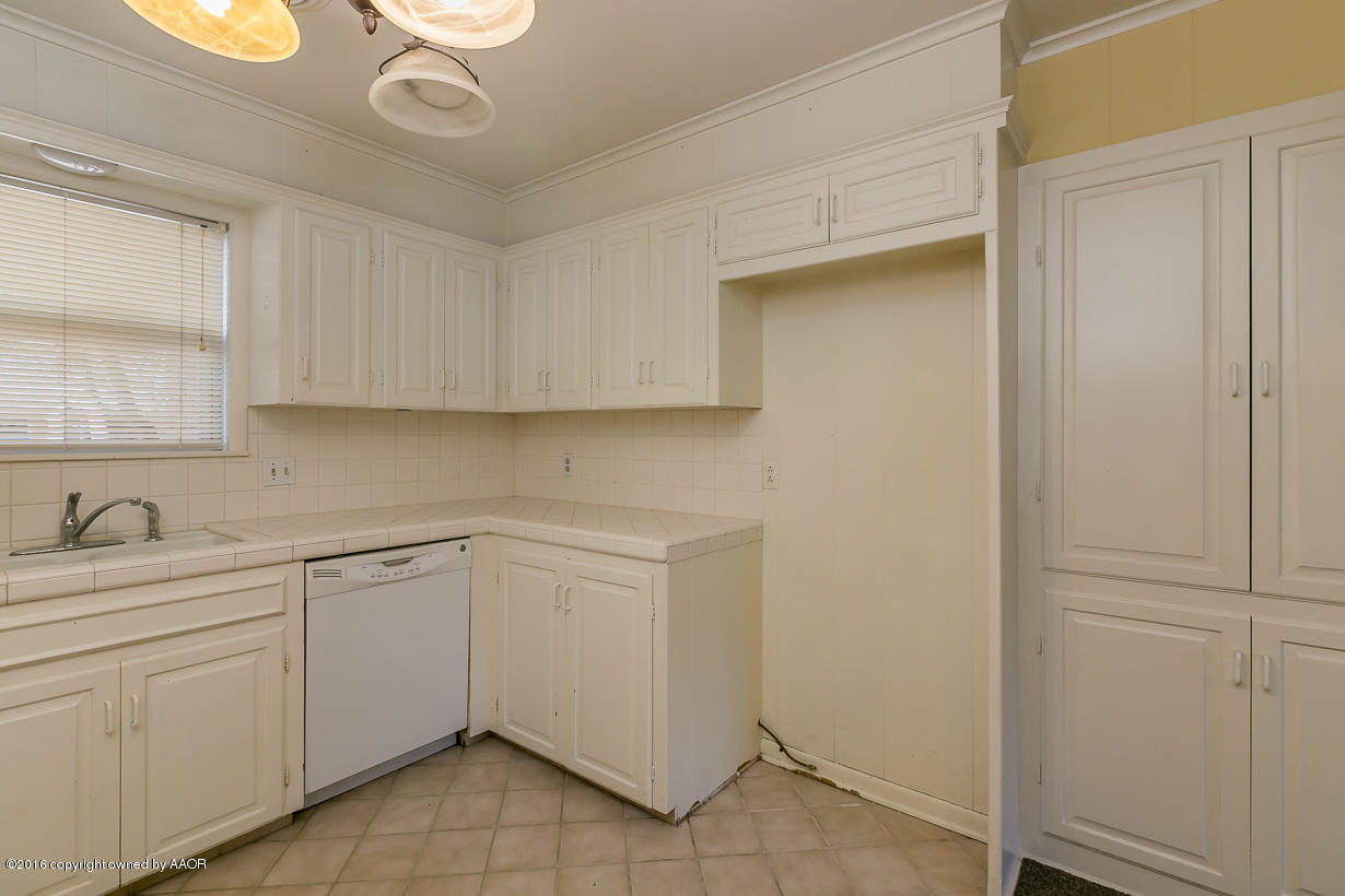 6107 Elmhurst Road Amarillo, TX 79106 - Photo 12 of 32 a kitchen with a sink cabinets and utility