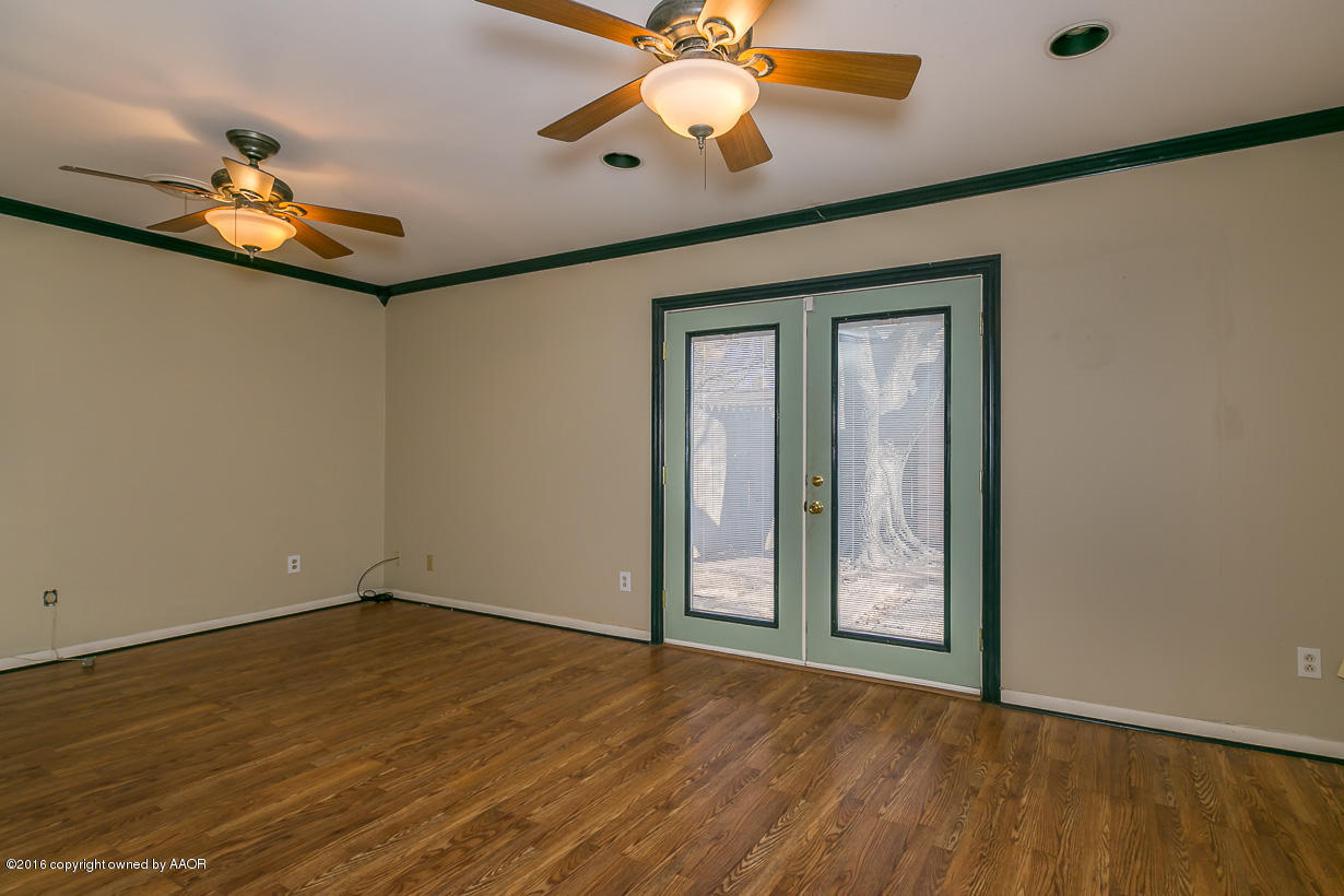 6107 Elmhurst Road Amarillo, TX 79106 - Photo 14 of 32 an empty room with wooden floor fan and windows
