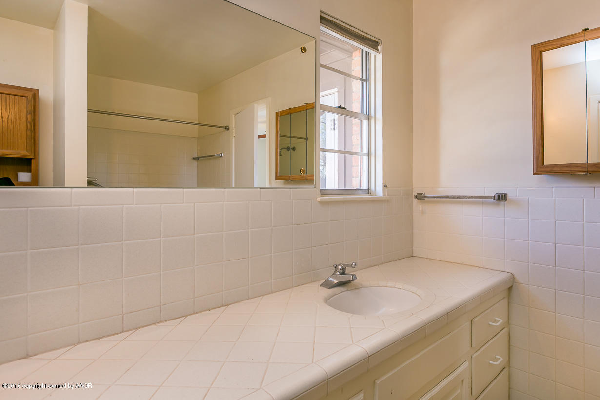 6107 Elmhurst Road Amarillo, TX 79106 - Photo 20 of 32 a bathroom with a sink and a mirror