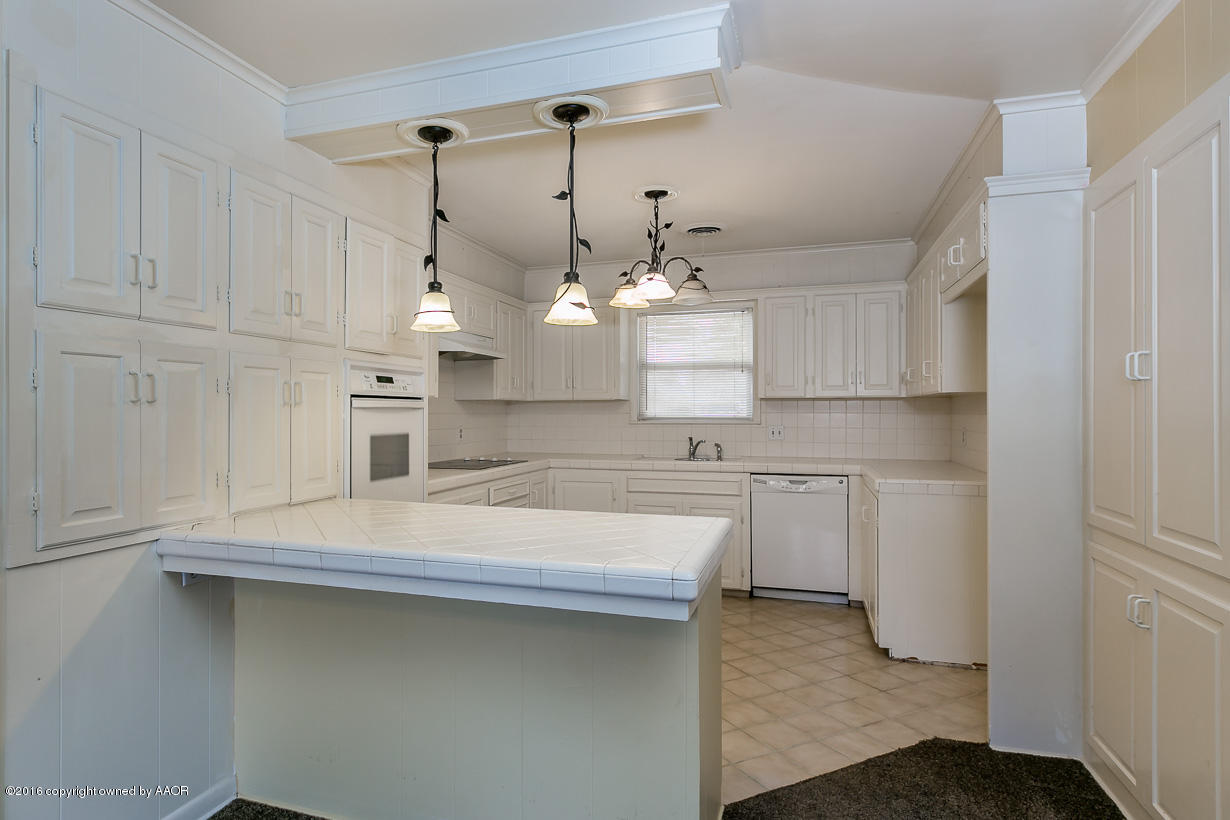 6107 Elmhurst Road Amarillo, TX 79106 - Photo 10 of 32 a kitchen with kitchen island white cabinets and refrigerator