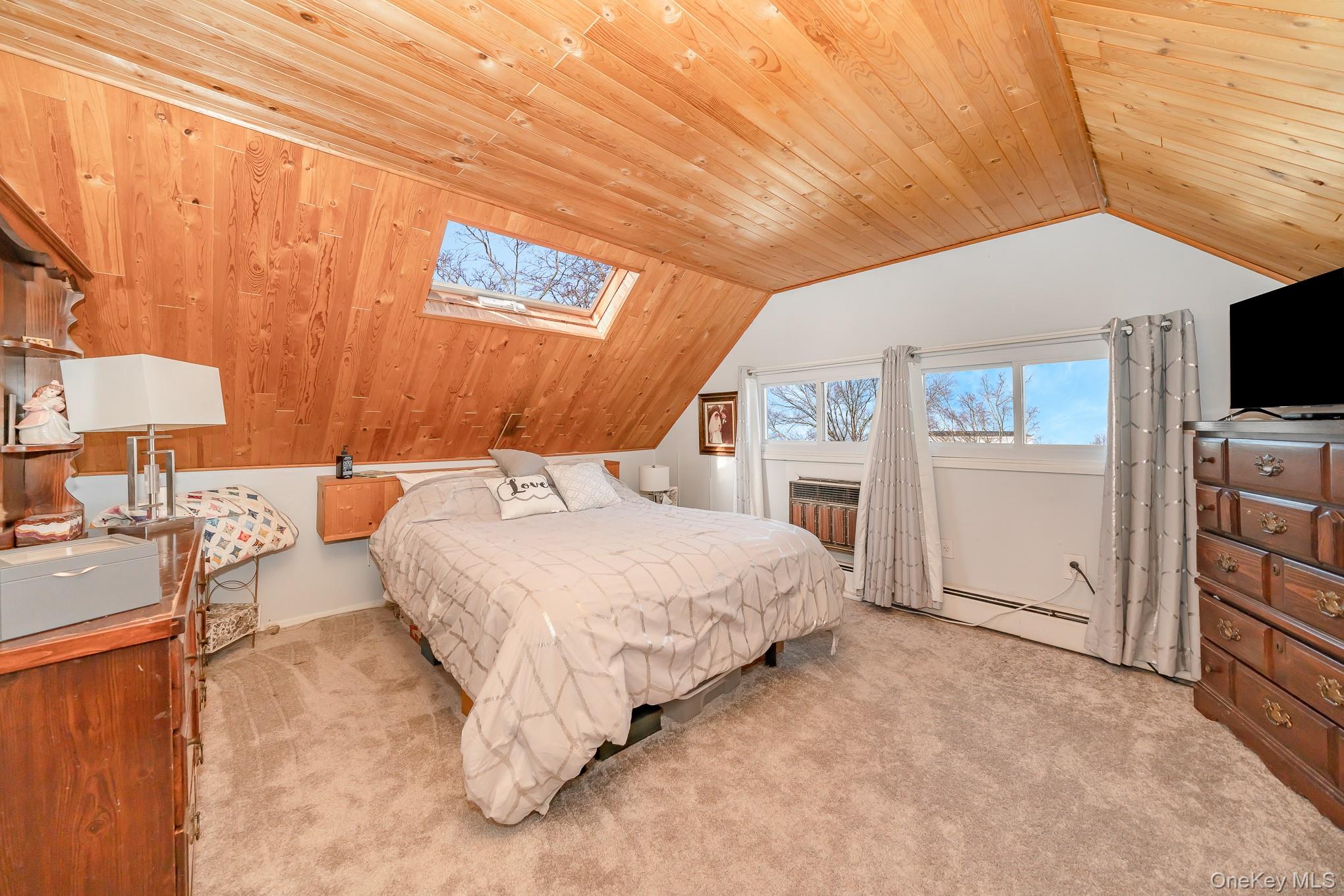 44 Disc Lane Wantagh, NY 11793 - Photo 17 of 26 a spacious bedroom with a bed and a flat screen tv