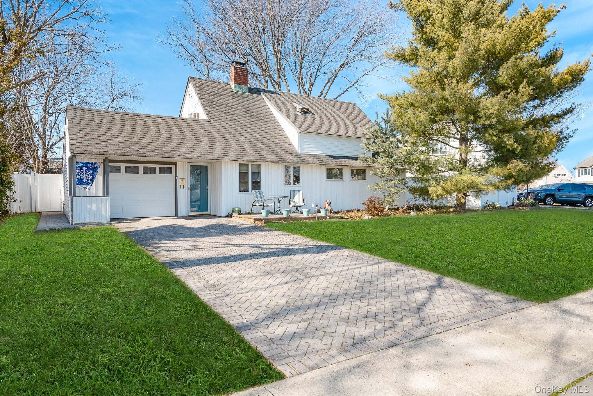 44 Disc Lane Wantagh, NY 11793 - Photo 2 of 26 a view of a white house with a big yard and large trees