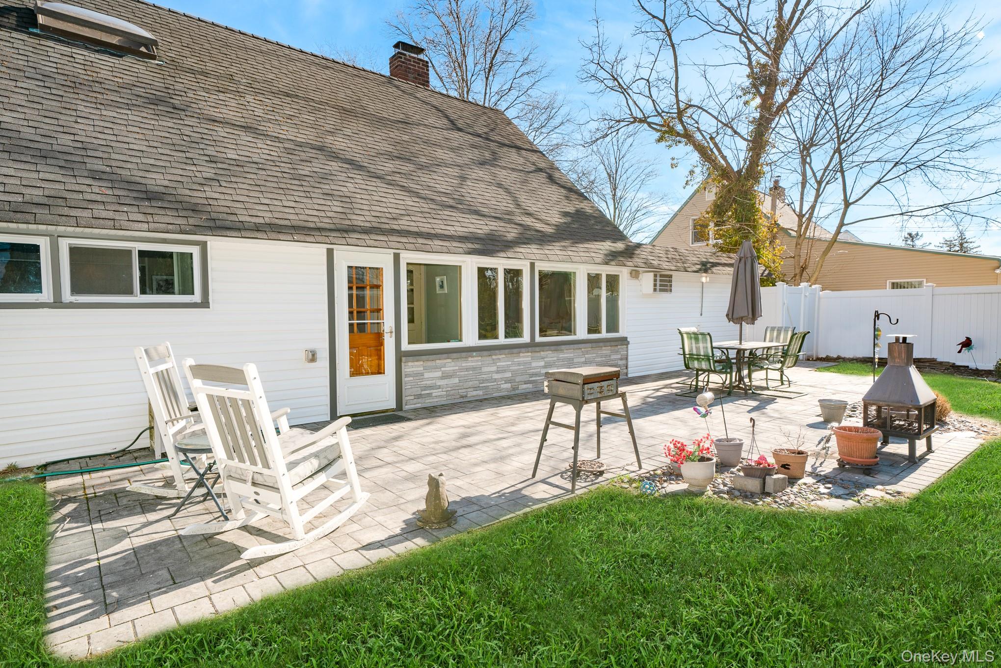 44 Disc Lane Wantagh, NY 11793 - Photo 21 of 26 a view of a backyard with table and chairs and a fire pit