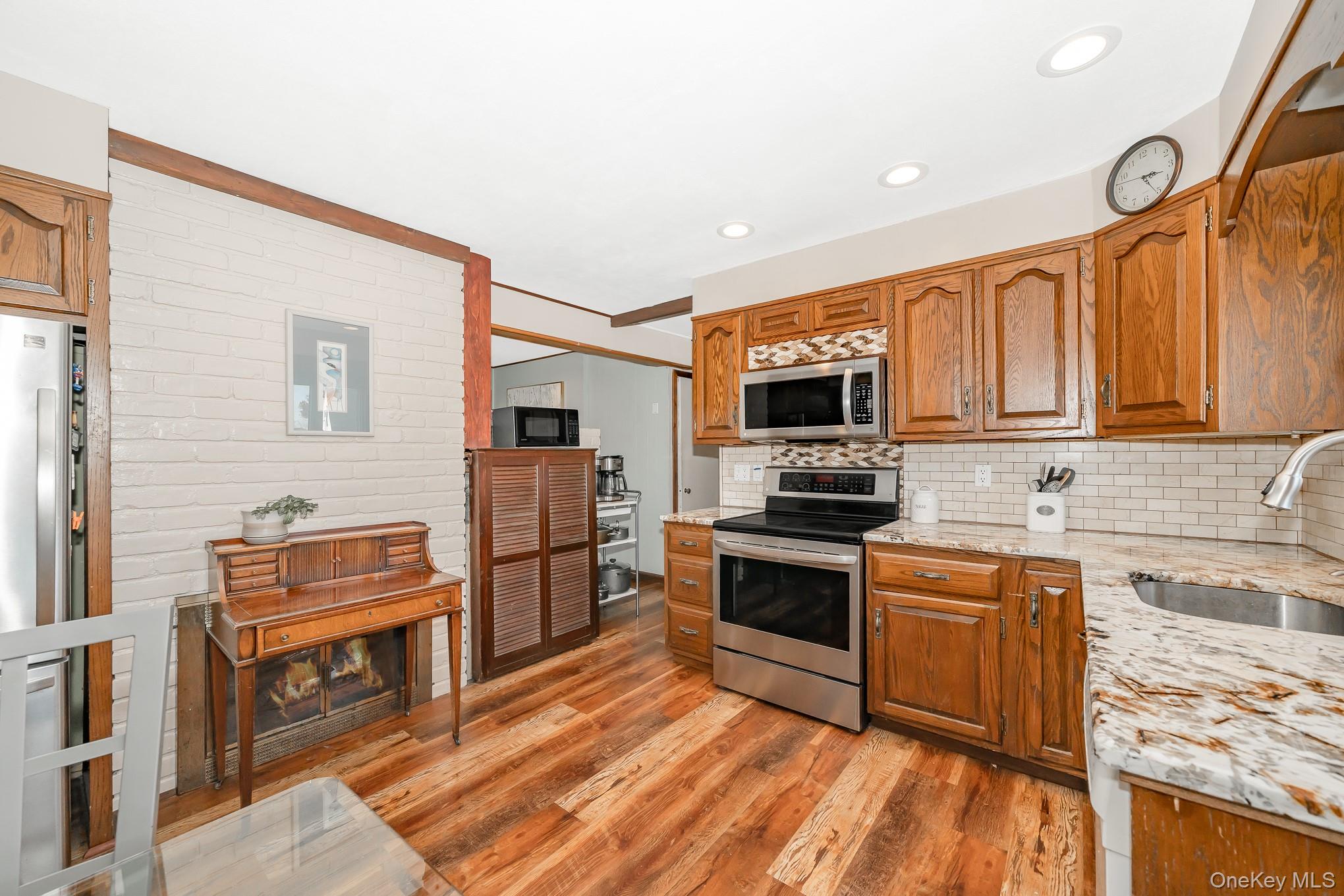 44 Disc Lane Wantagh, NY 11793 - Photo 6 of 26 a kitchen with stainless steel appliances granite countertop a stove top oven a sink dishwasher and a microwave oven with cabinets
