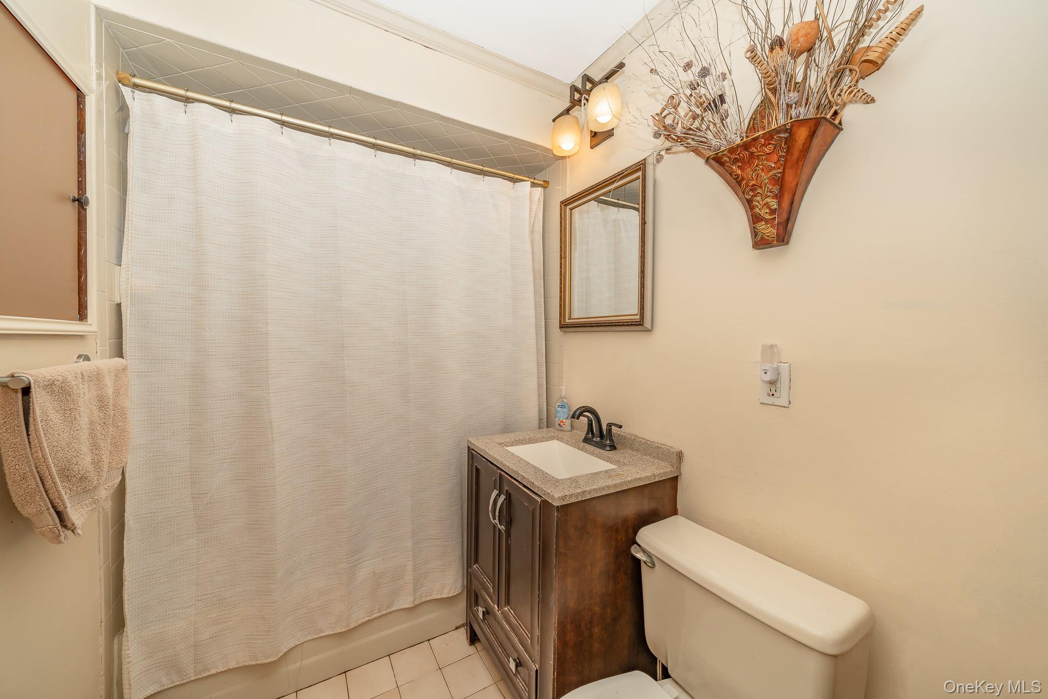 44 Disc Lane Wantagh, NY 11793 - Photo 10 of 26 a bathroom with a toilet sink and mirror