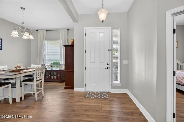 a view of a dining room and livingroom with furniture wooden floor and a rug