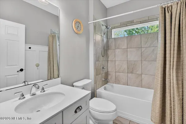 a bathroom with a granite countertop bathtub shower sink vanity and mirror