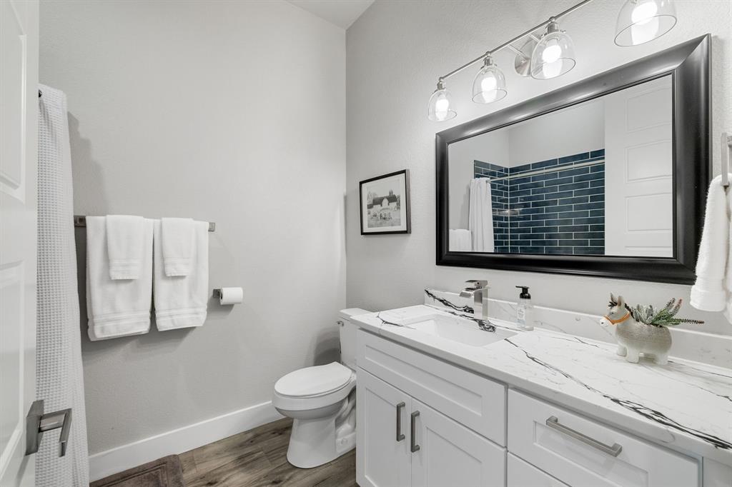 6811 Briar Road Azle, TX 76020 - Photo 21 of 34 a bathroom with a granite countertop toilet sink and mirror