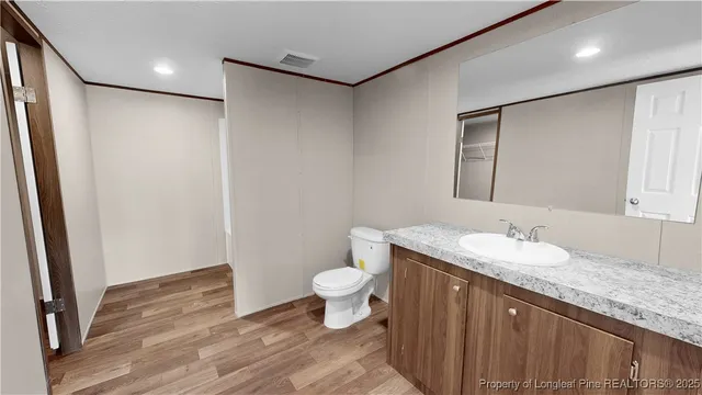 a bathroom with a granite countertop sink a toilet and a mirror