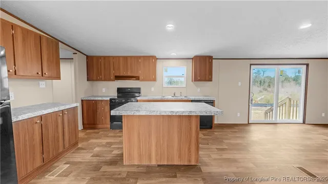 a kitchen with stainless steel appliances granite countertop a stove a sink and a microwave