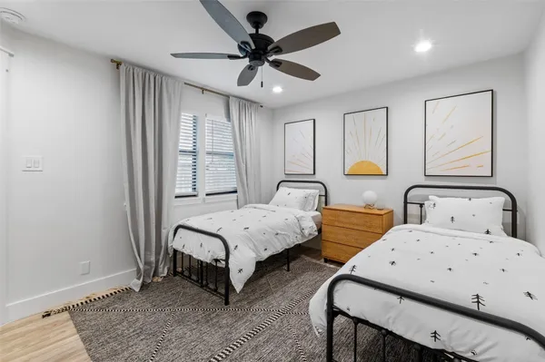 a bedroom with two beds and painting on the wall