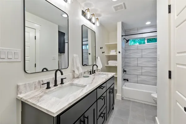 a bathroom with a tub sink and mirror