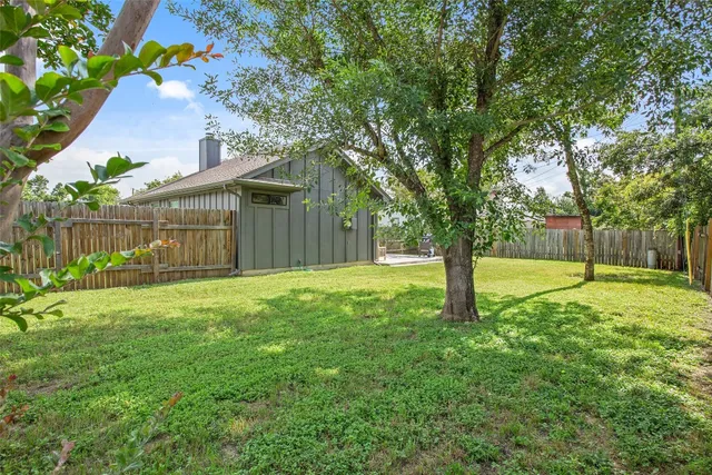 a view of a house with backyard and a tree