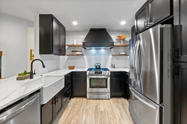 a kitchen with stainless steel appliances a sink stove and refrigerator