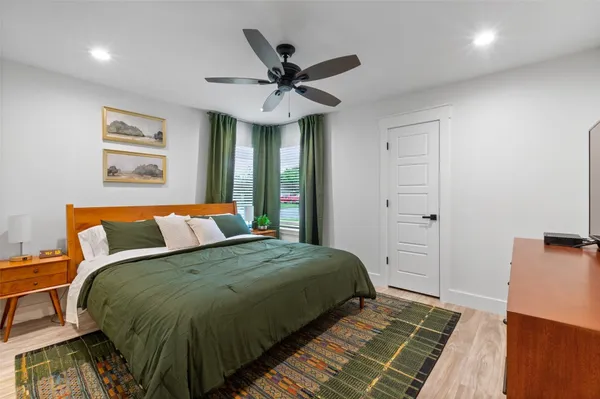 a bedroom with a large bed and a ceiling fan