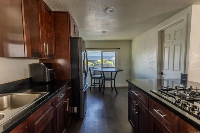 a kitchen with granite countertop wooden cabinets and a stove top oven