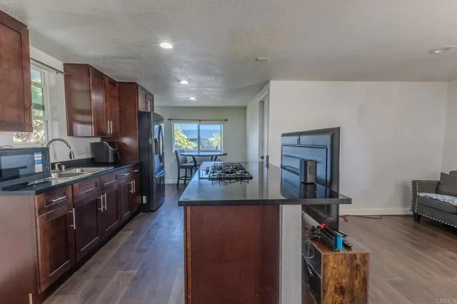 a large kitchen with a table chairs stove and refrigerator