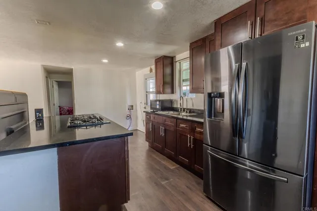 a kitchen with stainless steel appliances granite countertop a refrigerator and a stove
