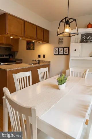 a kitchen with stainless steel appliances wooden floor dining table and chairs