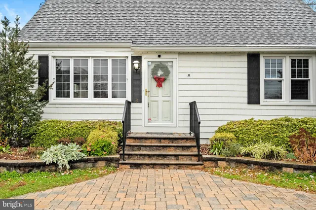 a front view of a house with a yard and potted plants