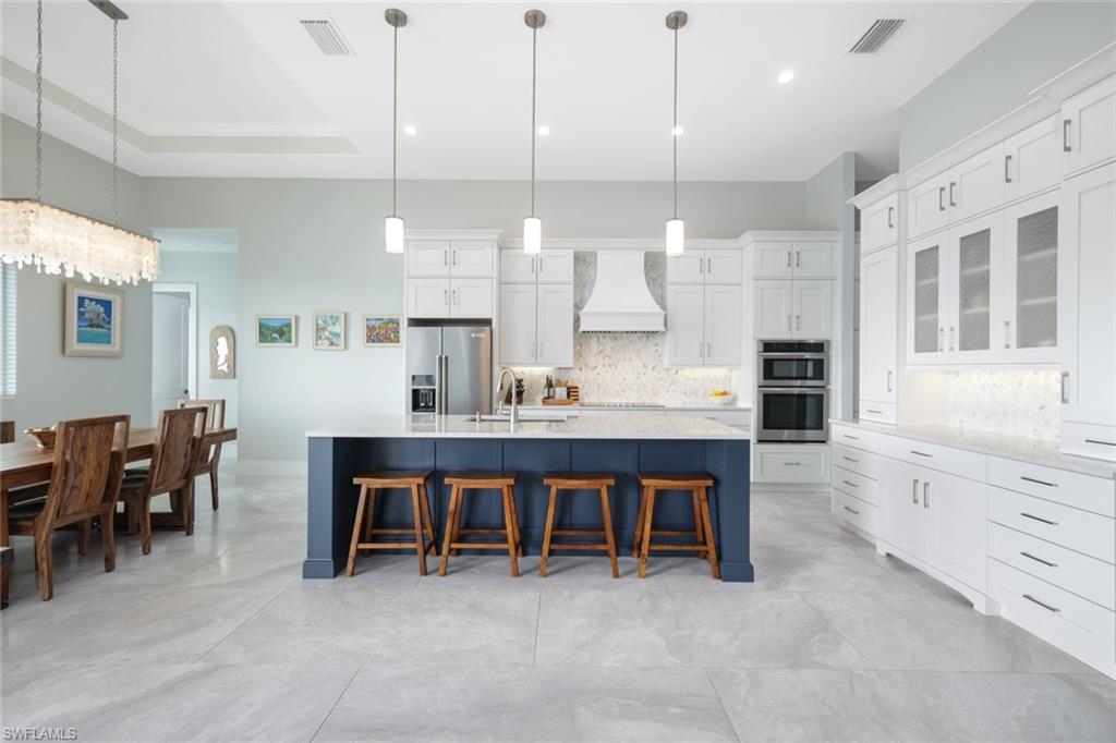 a large kitchen with kitchen island a island a sink stainless steel appliances and cabinets