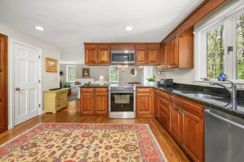 a kitchen with stainless steel appliances granite countertop a stove a sink and a microwave