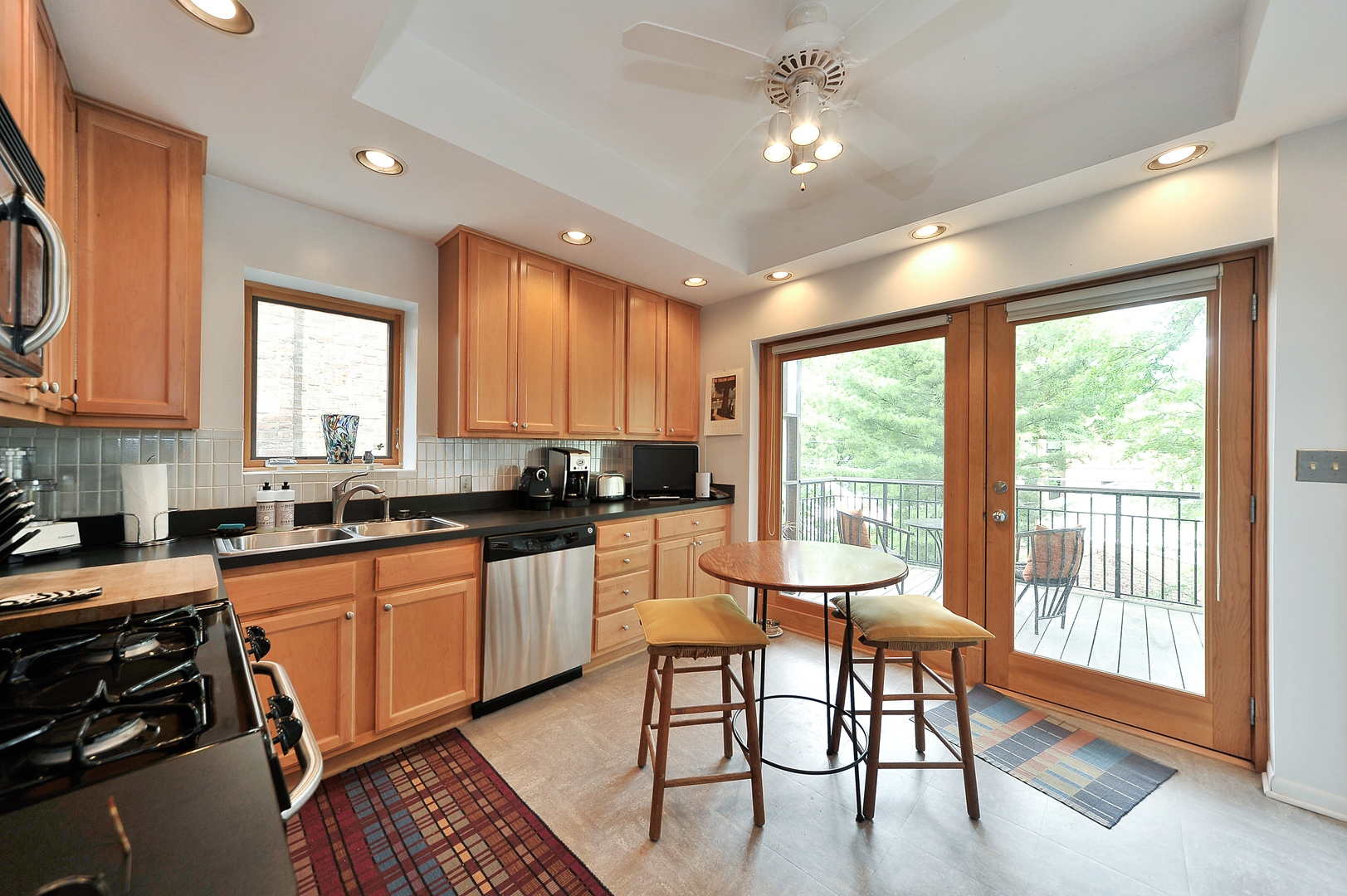 3729 North Wayne Avenue, Unit 2 Chicago, IL 60613 - Photo 6 of 12 a kitchen with stainless steel appliances granite countertop a stove top oven a sink dishwasher and a dining table with garden view