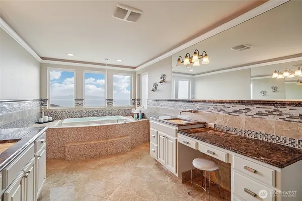 a bathroom with a granite countertop sink and a bathtub