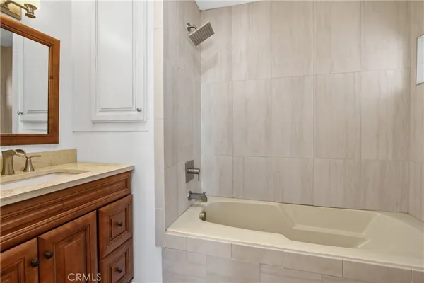 a bathroom with a sink a bathtub and a mirror