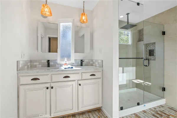 a bathroom with a sink vanity granite tub shower and a mirror