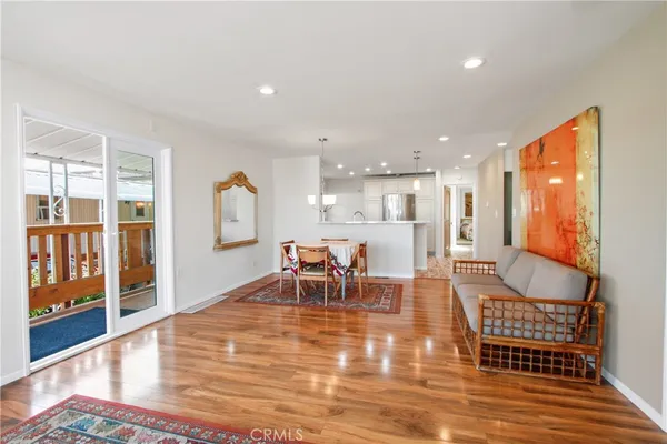 a living room with furniture a wooden floor and next to a window