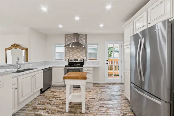 a kitchen with stainless steel appliances a refrigerator sink and stove