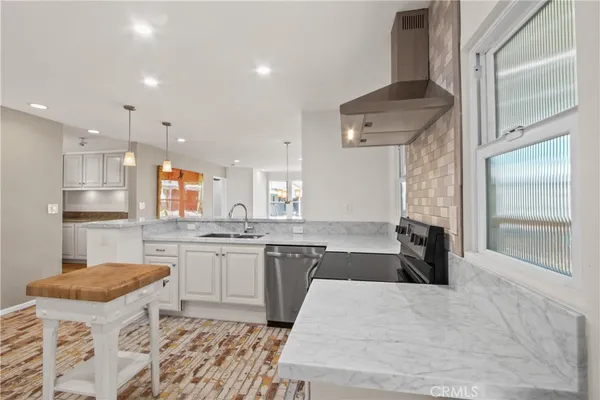 a kitchen with granite countertop a sink stove and refrigerator