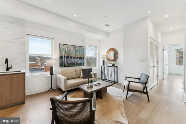 a living room with furniture and view of kitchen