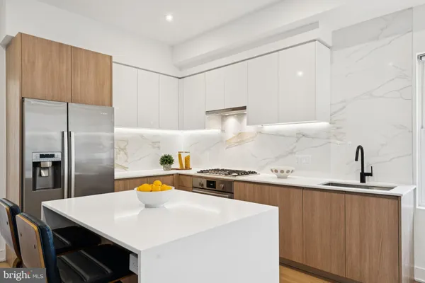 a kitchen with kitchen island a sink a stove and refrigerator