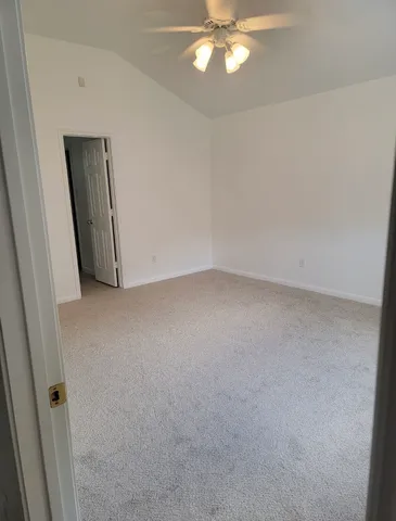 an empty room with a chandelier fan