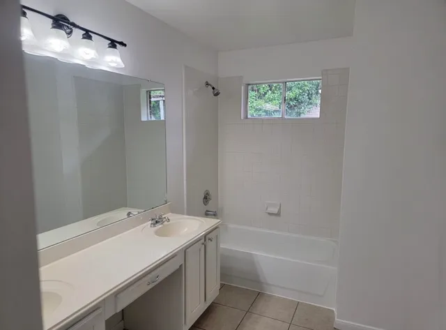 a bathroom with a tub sink and mirror