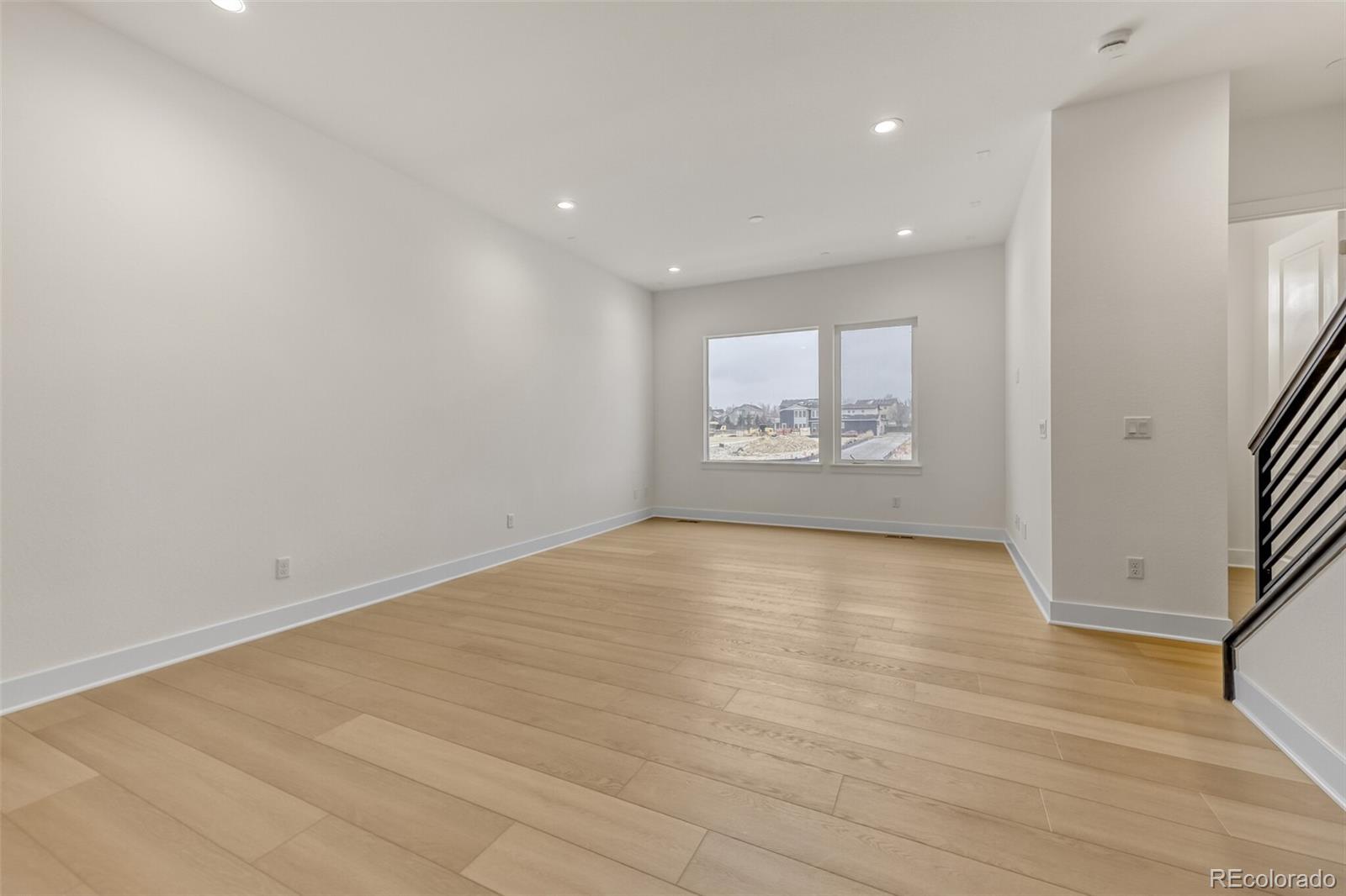 665 Skyhook Street Erie, CO 80516 - Photo 2 of 20 an empty room with wooden floor and windows