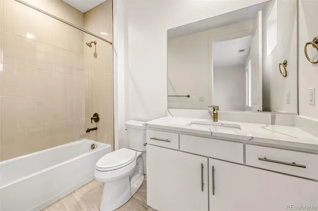 a bathroom with a sink toilet vanity and shower
