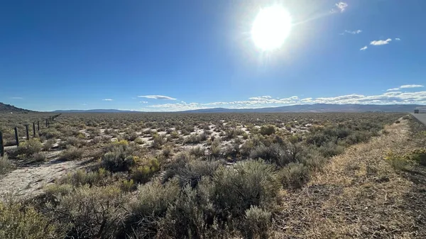 a view of a dry yard with mountains in the background