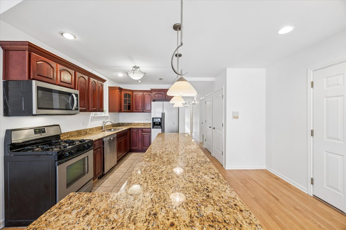 2363 East 70th Street, Unit 1 Chicago, IL 60649 - Photo 12 of 26 a kitchen with stainless steel appliances granite countertop a stove and cabinets