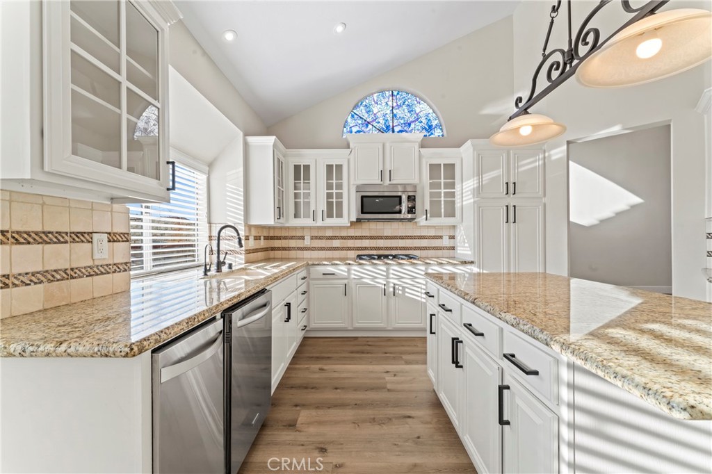 28241 Tamarack Lane Saugus, CA 91390 - Photo 11 of 41 a large white kitchen with a stove and a chandelier