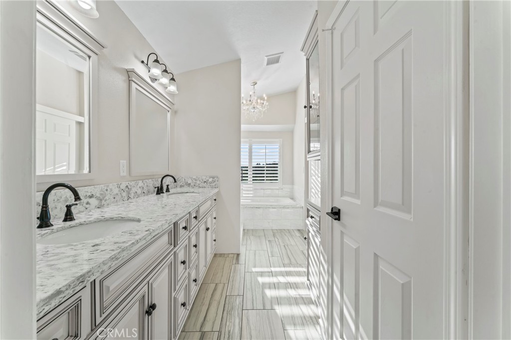 28241 Tamarack Lane Saugus, CA 91390 - Photo 22 of 41 a bathroom with a granite countertop sink a mirror a vanity and a shower