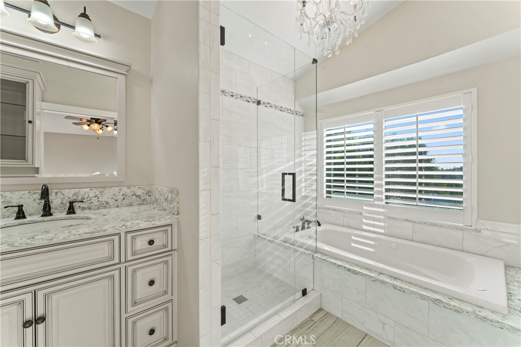 28241 Tamarack Lane Saugus, CA 91390 - Photo 23 of 41 a bathroom with a granite countertop sink a large mirror and a bathtub