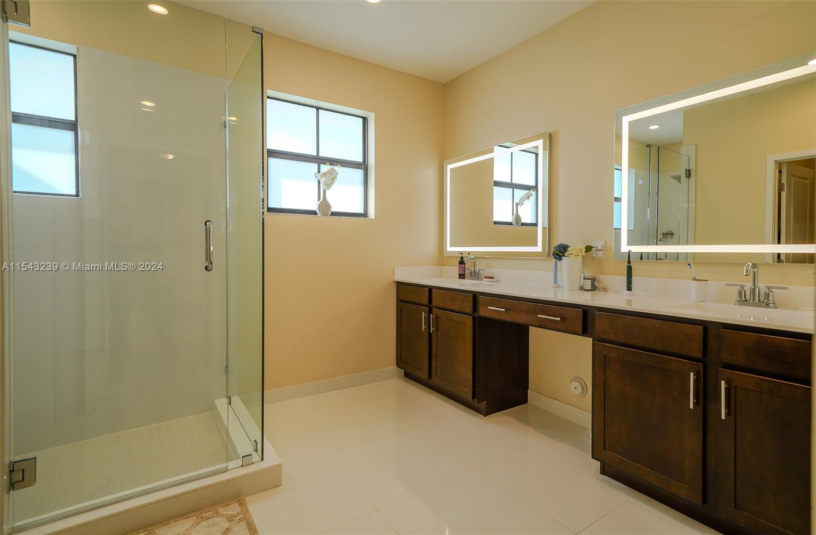 14570 Southwest 19th Street Miami, FL 33175 - Photo 14 of 30 a bathroom with a double vanity sink a large mirror and a bathtub