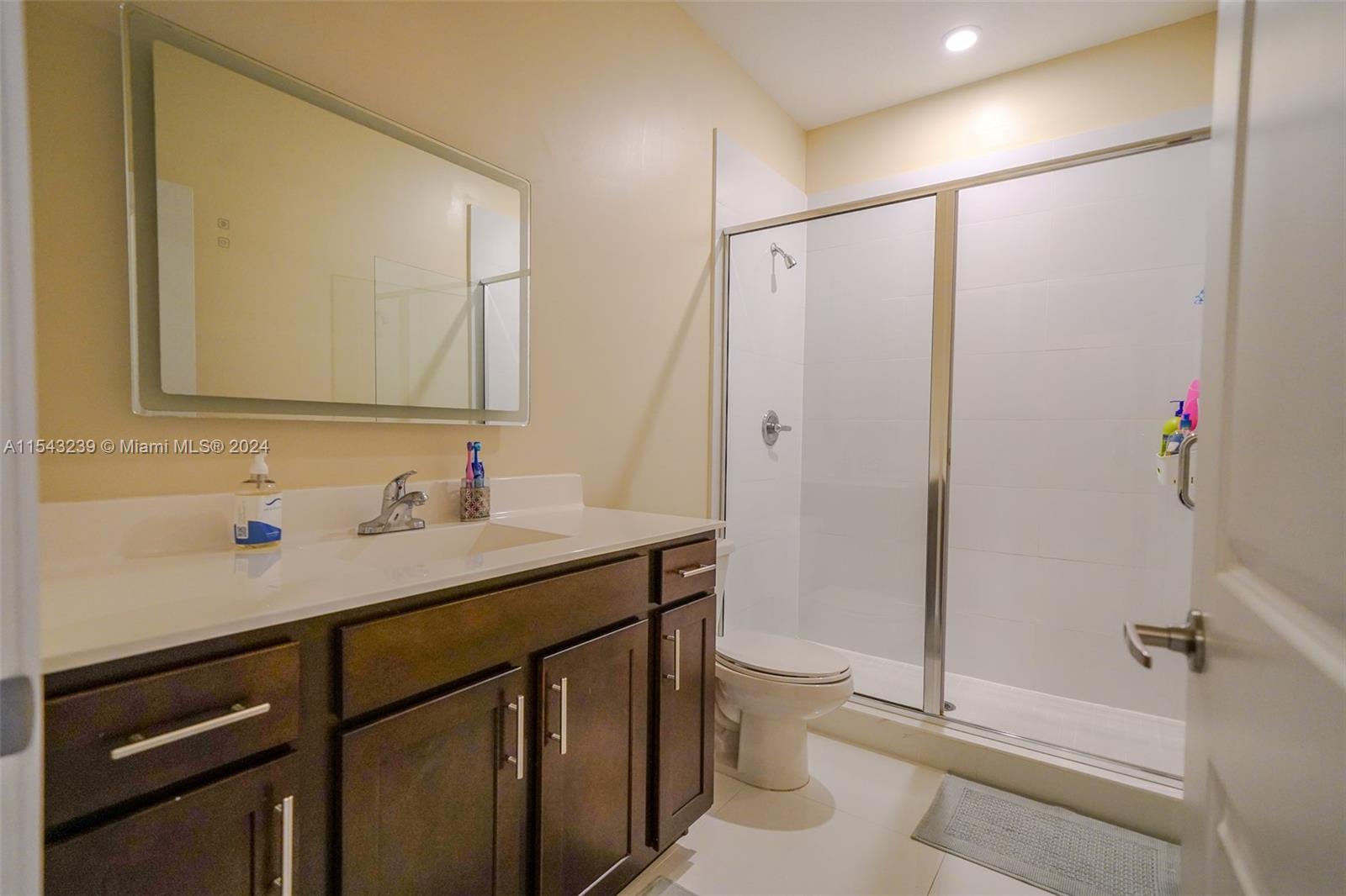 14570 Southwest 19th Street Miami, FL 33175 - Photo 19 of 30 a bathroom with a granite countertop sink toilet and shower
